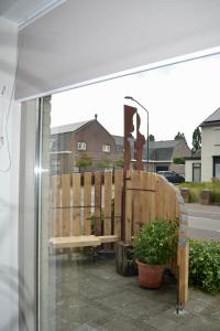 a bench sitting on a patio outside of a window at Bed and breakfast Art 7 in Heeswijk-Dinther