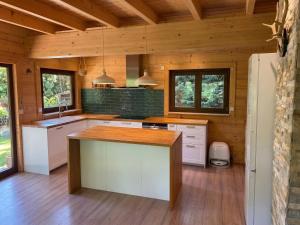 a kitchen with white cabinets and a wooden ceiling at Stausee-Haus in Neumühle