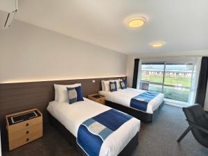 a hotel room with two beds and a window at Hideaway of Rotorua in Rotorua
