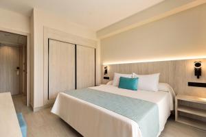 ein Schlafzimmer mit einem großen weißen Bett und einem blauen Kissen in der Unterkunft Hotel Best Mojácar in Mojácar