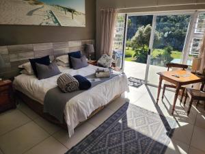 a bedroom with a large bed and a large window at Mackenzies Accommodation in East London +165 photos