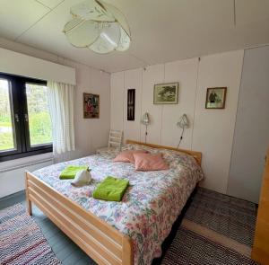 a bedroom with a bed with two green pillows on it at Mattilan talo b&b in Impiö
