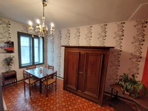 a dining room with a table and a wooden cabinet at Le Commerce in Bulgnéville