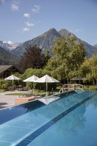 a swimming pool with a mountain in the background at VAYA Lechtal in Elbigenalp