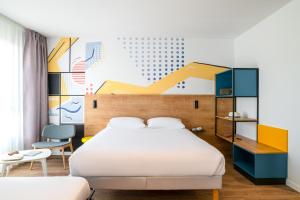 a bedroom with a bed and a colorful wall at ibis Styles Angouleme Centre in Angoulême +55 photos