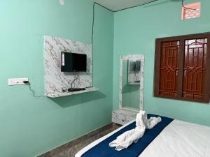 a room with a bed and a tv on the wall at Das & Das Hotel in Bhubaneshwar