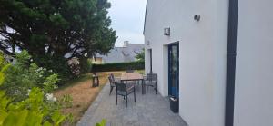 a patio with a table and chairs in a yard at Ker Giz 14 in Arzon