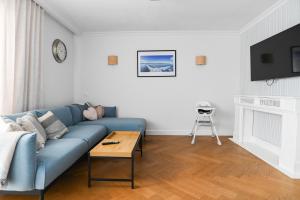 a living room with a blue couch and a table at Villa Laurent in Charzykowy