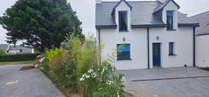 a white house with blue windows and a driveway at Ker Giz 14 in Arzon