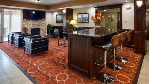Best Western Plus Crawfordsville Hotel في كروفوردزوفيل: يوجد بار في صالون مع كراسي ومدفأة