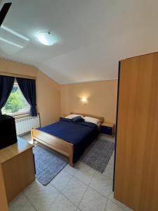 a bedroom with a blue bed and a window at Divlje vode in Stojdraga