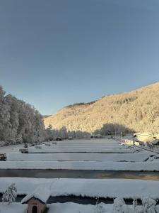 a field covered in snow next to a mountain at Divlje vode in Stojdraga +6 photos