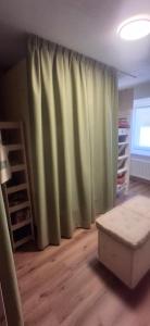 a living room with a green curtain and a bed at Inner Holiday Dolomites in Dimaro