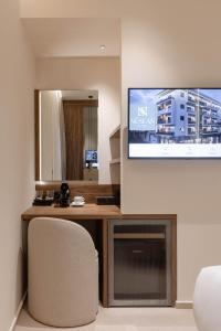 a room with a desk with a tv and a chair at Nesean Plaza Hotel in Heraklio