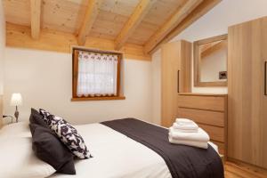 a bedroom with a bed and a wooden ceiling at Casa Chris by AMA Val di Fassa in Pozza di Fassa