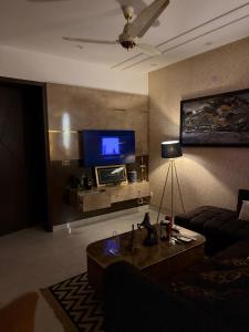 a living room with a couch and a flat screen tv at Prestige Home in Lahore