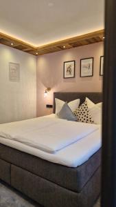 a bedroom with a large bed with white sheets at Chasa Patria Apartments in Ischgl