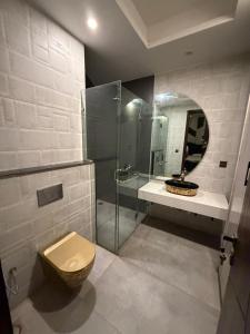 a bathroom with a toilet and a glass shower at Prestige Home in Lahore
