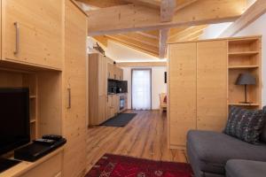 a living room with a couch and a room with wooden walls at Casa Chris by AMA Val di Fassa in Pozza di Fassa