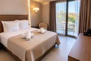 a hotel room with a bed with towels on it at Stella View in Pefki