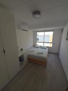 a small bedroom with a bed and a window at Simat Malina 2 in Simat de Valldigna