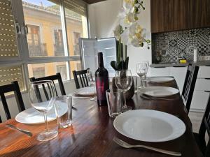 a dining room table with a bottle of wine and glasses at Simat Malina 2 in Simat de Valldigna