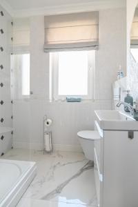 a white bathroom with a sink and a toilet at Villa Laurent in Charzykowy +22 photos