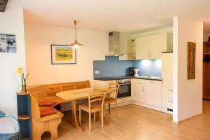 a kitchen and dining room with a table and chairs at Ferienwohnung Risthof 4 in Owingen