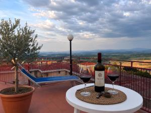 a bottle of wine sitting on a table with two glasses at Hotel Cristallo - Chianciano Terme in Chianciano Terme