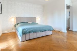 a bed in a room with a wooden floor at Villa Laurent in Charzykowy