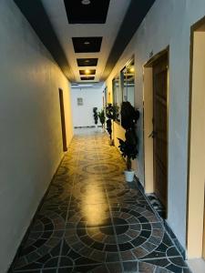 a hallway of an office building with a tile floor at Royal Palace in Naran +2 photos