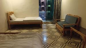 a room with two chairs and a bed and a window at Royal Palace in Naran