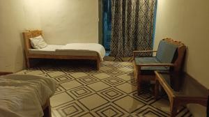 a room with a bedroom with a bed and a chair at Royal Palace in Naran