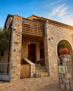 a brick house with a porch and a staircase at Lidori Mani in Akhíllion