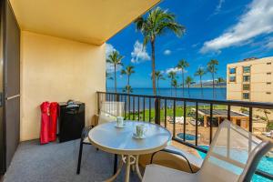 a balcony with a table and chairs and a view of the ocean at SUGAR BEACH RESORT #412 in Kihei