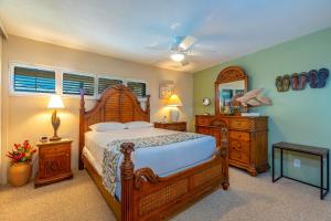a bedroom with a bed and a dresser and a mirror at SUGAR BEACH RESORT #412 in Kihei