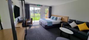 a hotel room with a bed and a couch at Hideaway of Rotorua in Rotorua