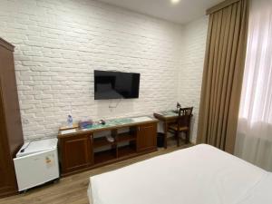 a hotel room with a bed and a tv on a wall at Orda Hotel in Yunusobod