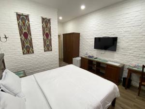 a bedroom with a bed and a flat screen tv at Orda Hotel in Yunusobod