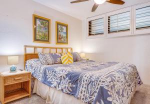 a bedroom with a bed and a ceiling fan at KIHEI SURFSIDE #109 in Wailea