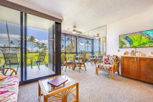 a living room with a balcony with a table and chairs at KIHEI SURFSIDE #109 in Wailea +25 photos