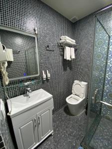 a bathroom with a toilet and a sink and a shower at Orda Hotel in Yunusobod