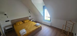 a bedroom with a bed with yellow sheets and a window at Ker Giz 14 in Arzon
