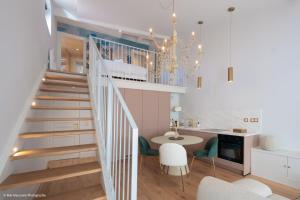 a staircase in a living room with a table and chairs at Duplex charmant dans le centre - La suite Incas in Le Puy-en-Velay