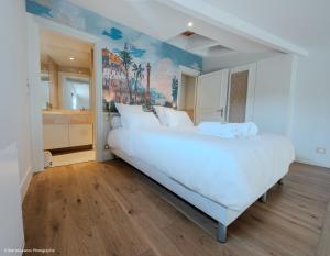 a bedroom with a large white bed in a room at Duplex charmant dans le centre - La suite Incas in Le Puy-en-Velay