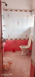 a bathroom with a toilet and red walls at Mayurbhanj Stay Inn in Baripāda