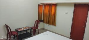 a room with two chairs and a table with a pizza on it at Mayurbhanj Stay Inn in Baripāda