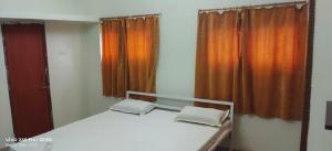 a bedroom with a bed and a window with curtains at Mayurbhanj Stay Inn in Baripāda