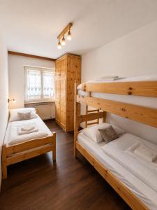 a bedroom with two bunk beds and a window at Appartamento Cuore by AMA Val di Fassa in Campitello di Fassa