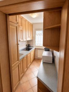 a kitchen with wooden cabinets and a counter top at Appartamento Cuore by AMA Val di Fassa in Campitello di Fassa
